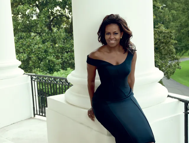 Michelle Obama in a bold new look, posing outdoors in an elegant off-shoulder black dress, praising makeup artist.