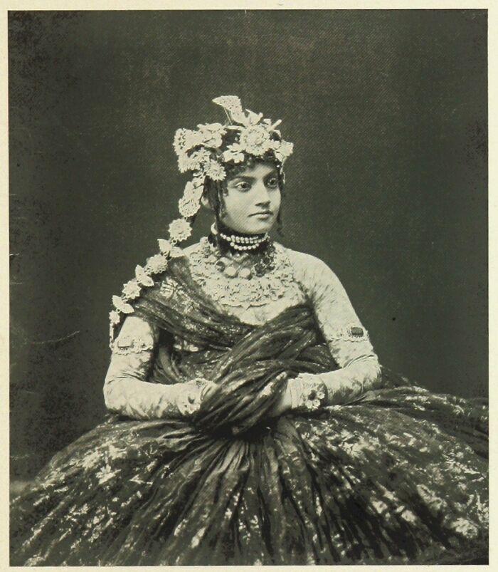 Vintage black and white photo of a woman in traditional attire capturing culture and emotion from the past.