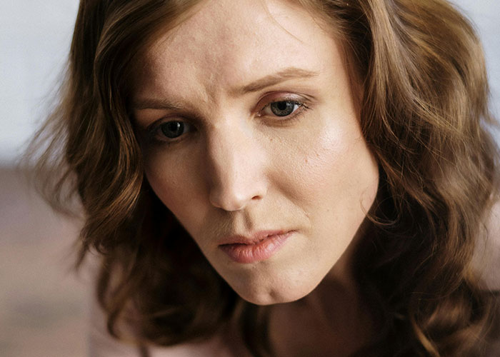 Close-up of a woman looking shocked and upset, reflecting reactions to unhinged things a mother-in-law just said.