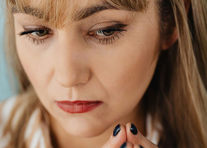 Close-up of a woman with thoughtful expression, reflecting on wild stories shared about their ex behavior.