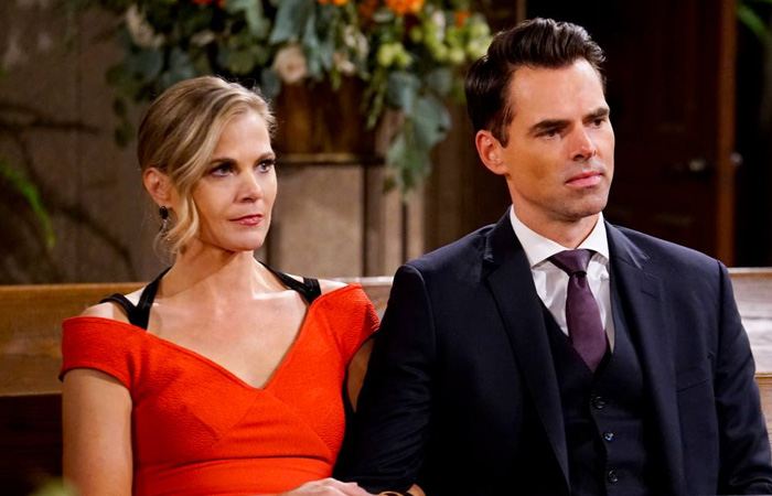 Two actors from a long-running TV show sit side by side, dressed formally, in a dramatic indoor scene.