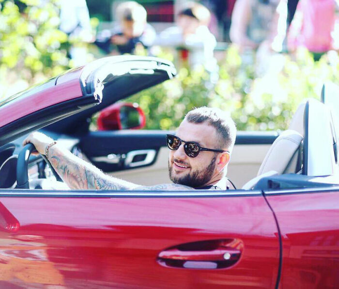 Man with sunglasses smiling while sitting in red convertible car, related to crypto scammer case news in Dubai. Man with sunglasses smiling while sitting in red convertible car, related to crypto scammer case news in Dubai.