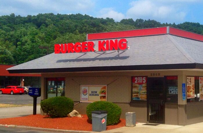 Burger King exterior with signs and parking lot, capturing a moment people instinctively felt something was wrong.