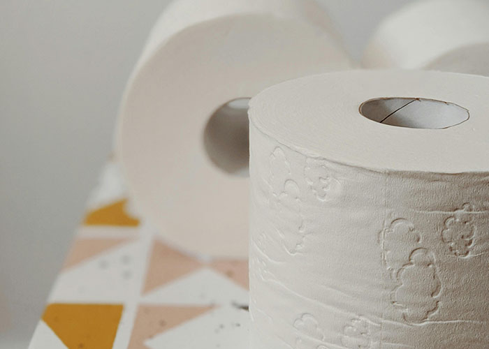 Close-up of toilet paper rolls on a patterned surface, illustrating one of the most insane things an ex ever did shared in stories.