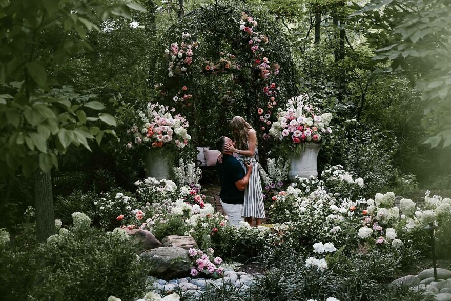 Couple embraces in a lush garden surrounded by flowers, capturing one of the most unforgettable 2025 pop culture moments.