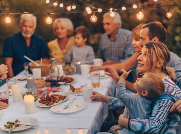 Family gathered outdoors for a meal, depicting tension and emotions related to repressed rage at MIL in a casual setting.