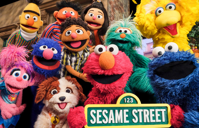 Sesame Street characters posing together on set, representing one of the longest running TV shows of all time.
