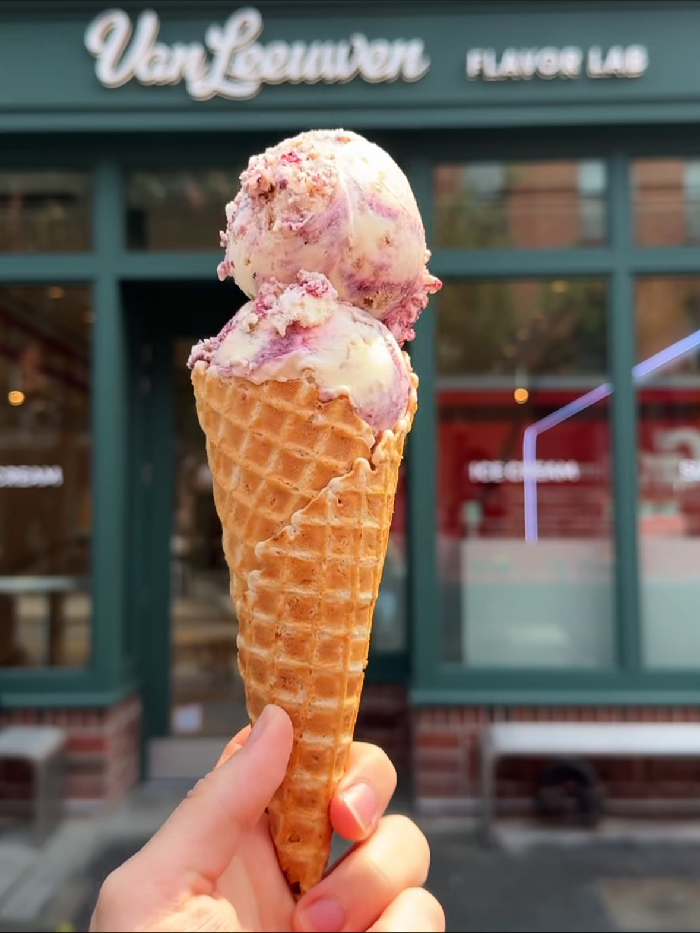 Van Leeuwen ice cream cone held in hand outside a New York City flavor lab shop in NYC.