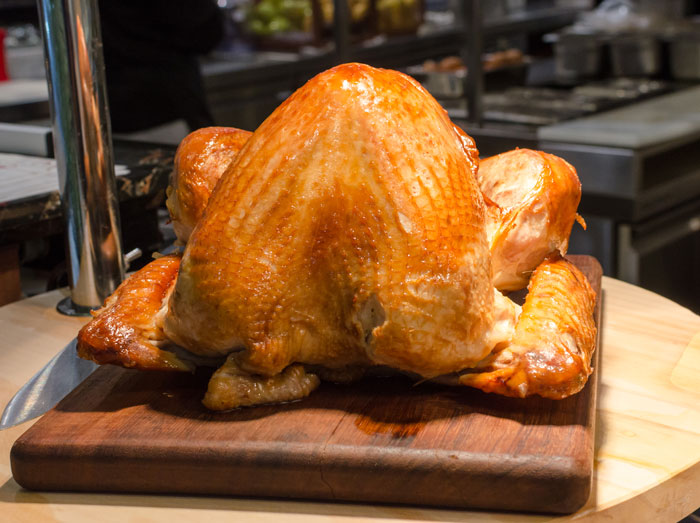 Roast turkey on wooden cutting board, a popular choice among white elephant gifts everyone tried to steal.