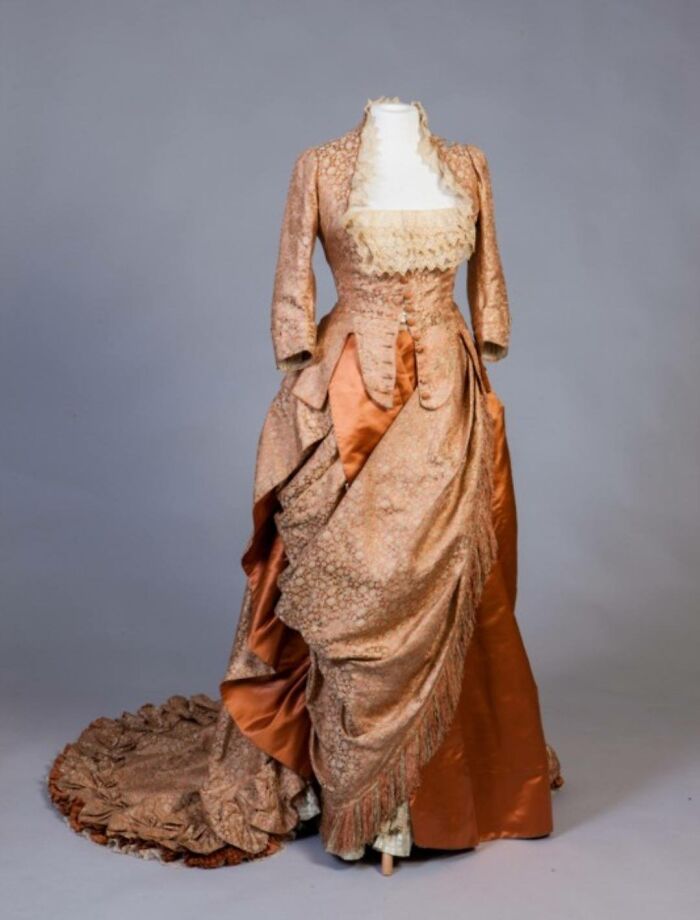 Vintage Victorian-era dress on a mannequin showcasing historic culture and everyday life from the past in a powerful old photo.