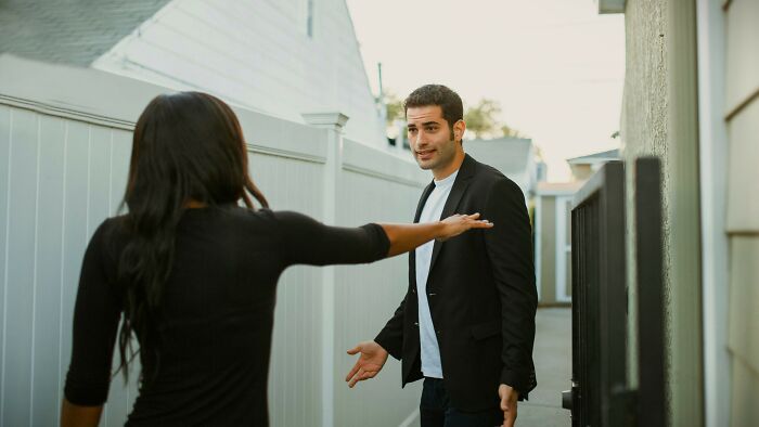 Two individuals debating in a narrow outdoor corridor, illustrating ambiguous situations for voting on who’s at fault.