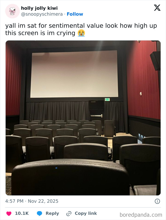 Empty movie theater seats facing a screen placed unusually high, illustrating a worst movie theater experience.