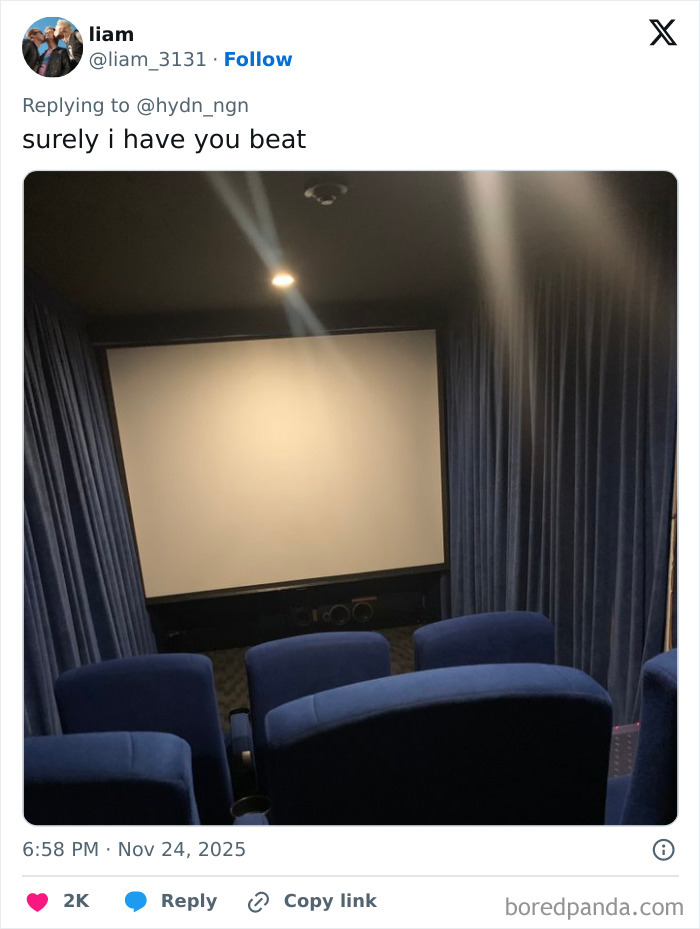 Small, poorly lit movie theater with blue seats and a blank screen, highlighting worst movie theaters experiences.