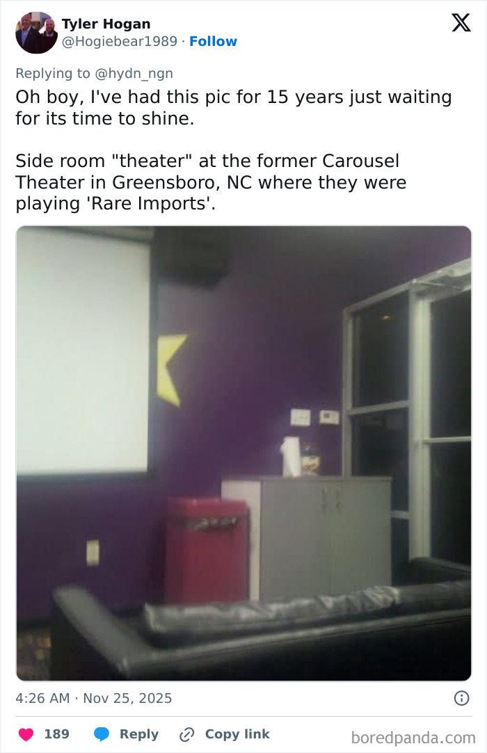 Small side room used as a movie theater with a couch, purple walls, and a screen in a worst movie theater setting.