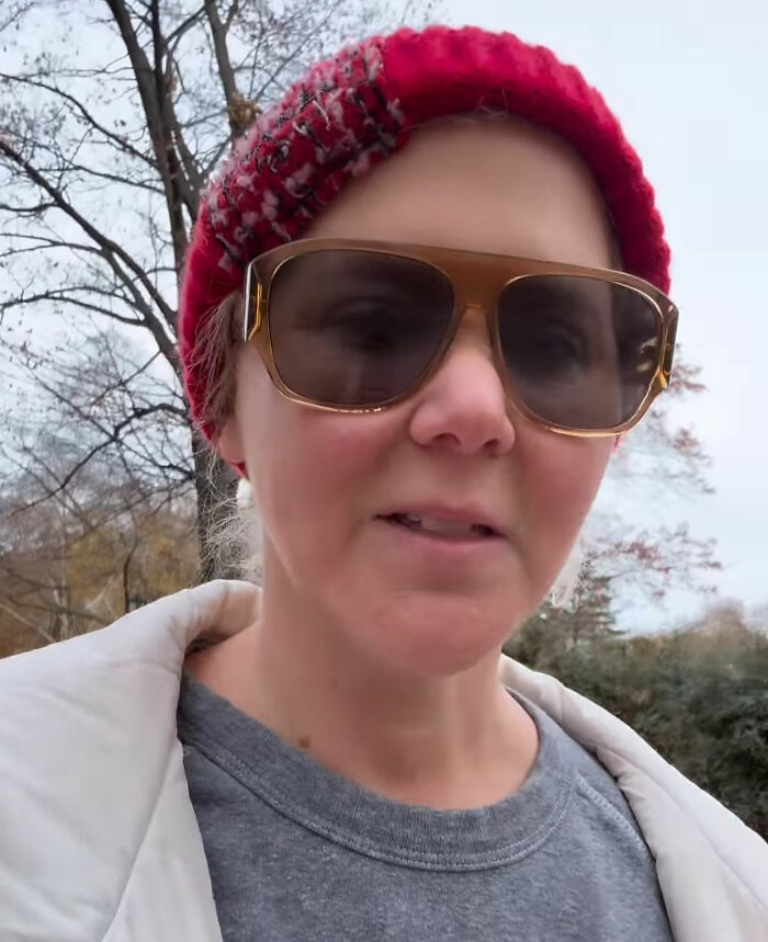 Amy Schumer wearing sunglasses and a red beanie outdoors showing off dramatic weight loss in casual attire.