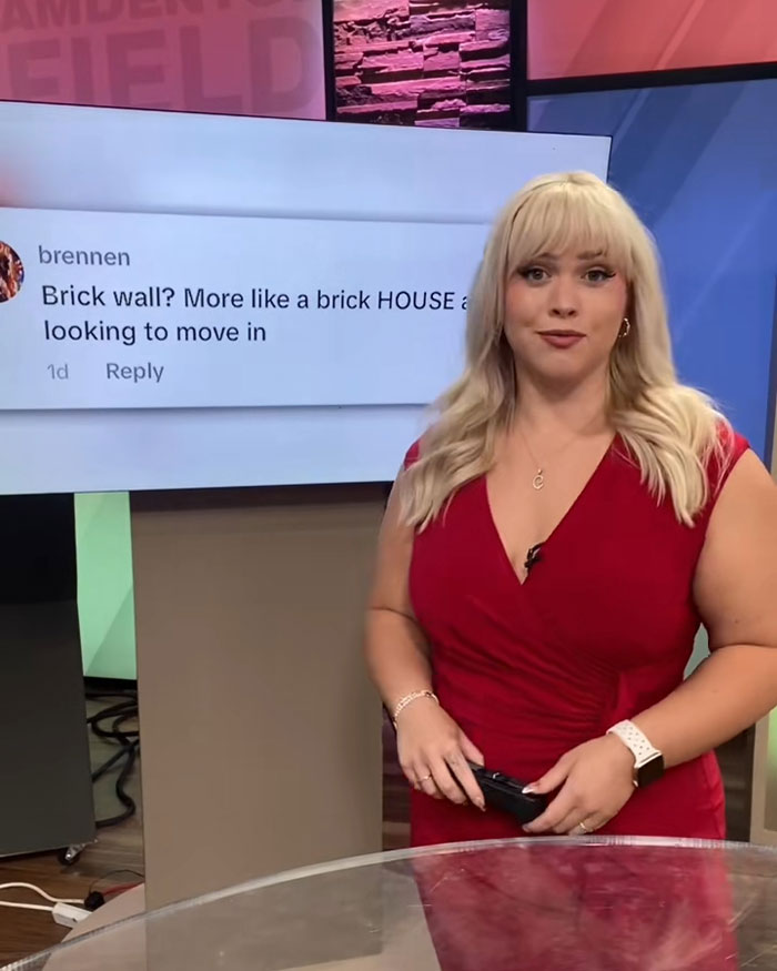 Curvy news anchor in red dress responds to viewer comments during a broadcast in a studio setting. Curvy news anchor in red dress responds to viewer comments during a broadcast in a studio setting.