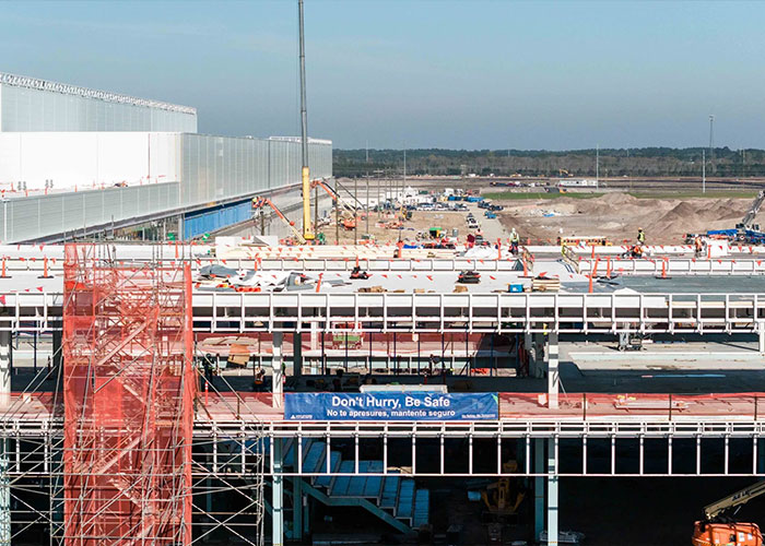 Construction site with workers and equipment, highlighting forklift accident safety concerns after CEO's tragic incident.