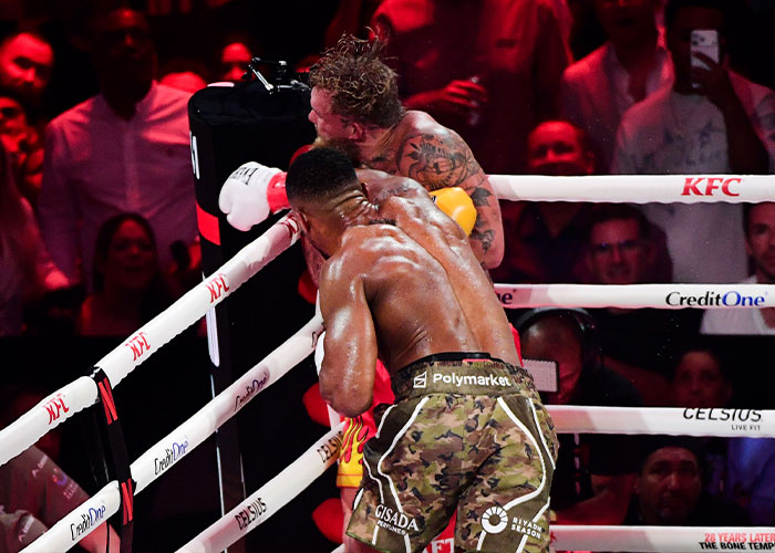 Boxer landing a punch during a match, highlighting Jake Paul&rsquo;s broken jaw as the latest internet punchline in boxing.