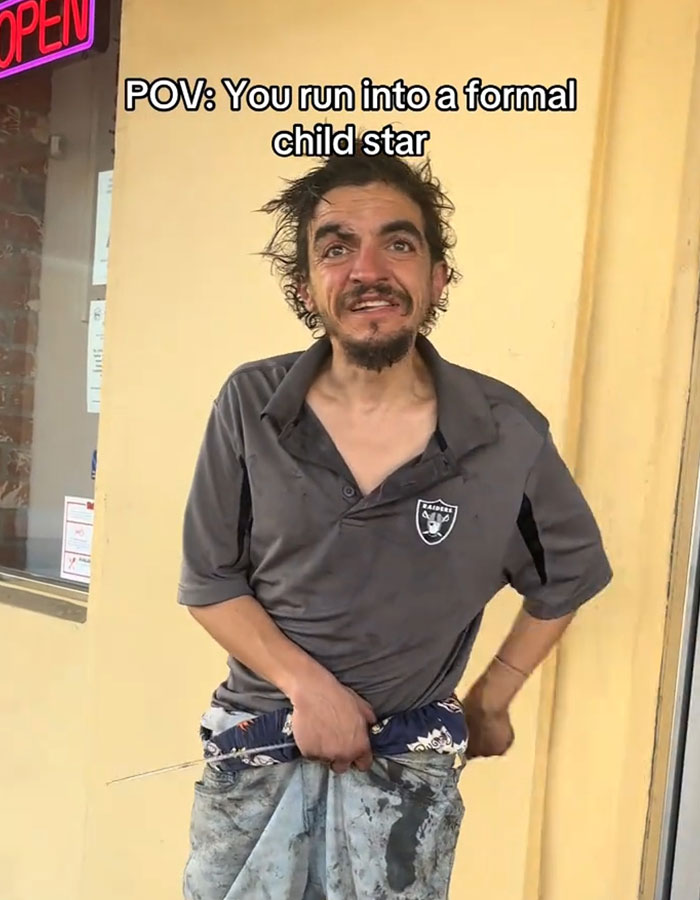 Homeless dad of Nickelodeon star Tylor Chase standing outside a building with unkempt hair and worn clothes.