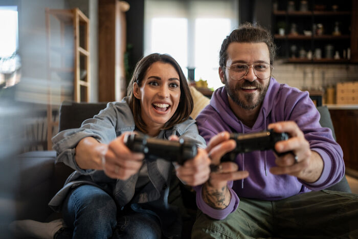 Couple enjoying at-home date night playing video games together in a cozy living room setting.