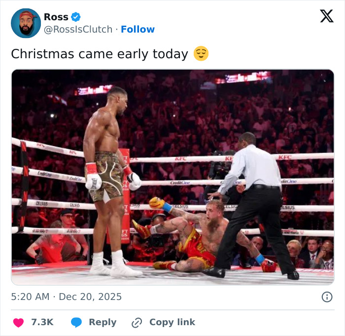 Boxer standing victorious while Jake Paul lies on the mat after a knockout, highlighting Jake Paul's broken jaw.