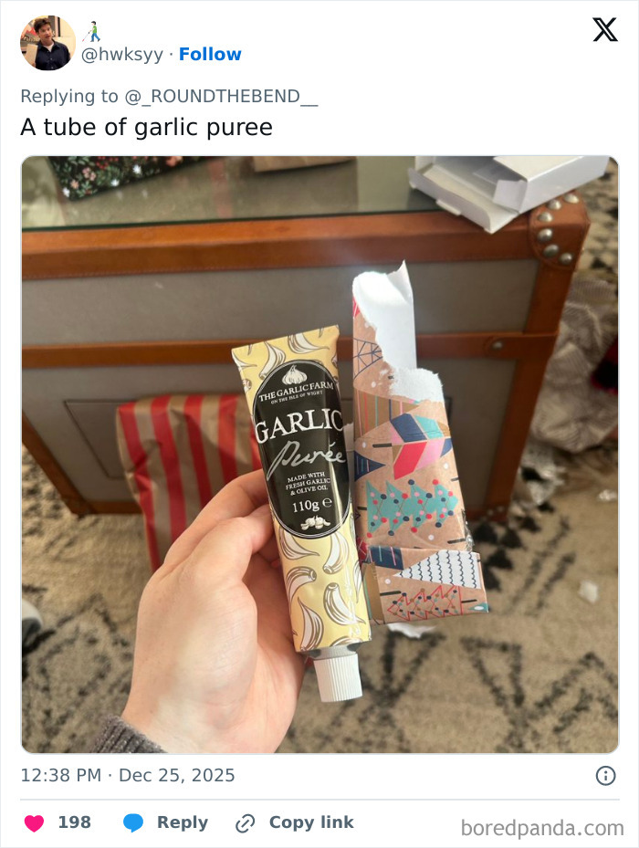 Hand holding a tube of garlic puree wrapped as a funny and unusual worst Xmas present idea this holiday season.