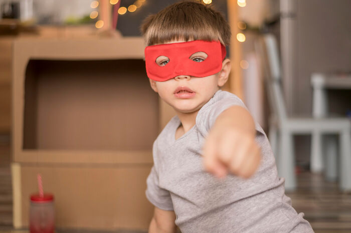 Young boy wearing a red mask pretending to be a superhero during an embarrassing moment people were blessed to see.