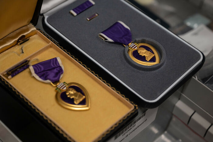 Two Purple Heart medals in open display cases highlighting people online share crazy facts about military awards.
