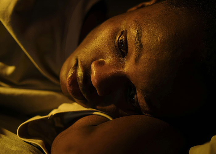 Person lying down with a thoughtful expression reflecting on wild stories about the most insane thing their ex ever did.