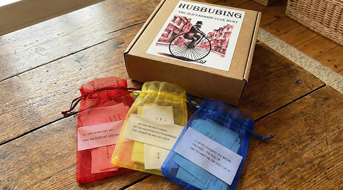 Party game components with colorful bags and clue cards displayed on a wooden table for the best party game.