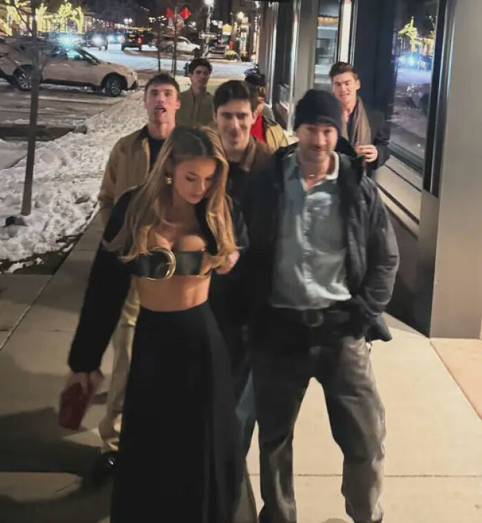 Brooks Nader wearing a $1,260 Santa belt as a shirt while walking with friends on a snowy Aspen sidewalk at night