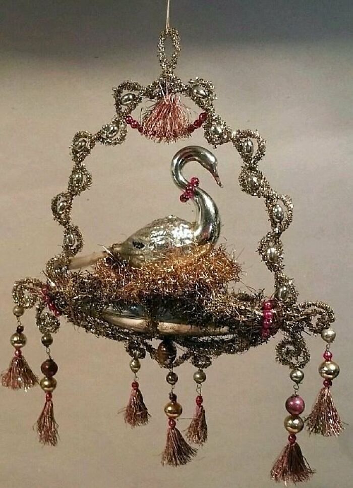 Vintage silver swan ornament with intricate beaded and tassel decorations, showcasing culture and everyday life in the past.