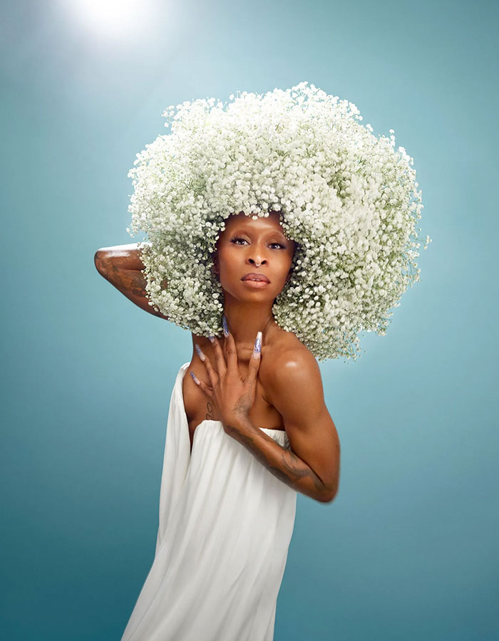 Cynthia Erivo posing in white dress with large floral headpiece, reflecting Ariana influence and Wicked For Good success. Cynthia Erivo posing in white dress with large floral headpiece, reflecting Ariana influence and Wicked For Good success.