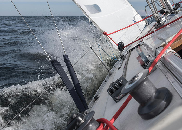 Sailboat navigating choppy waters in a remote and isolated place, capturing a creepy and mysterious atmosphere at sea.