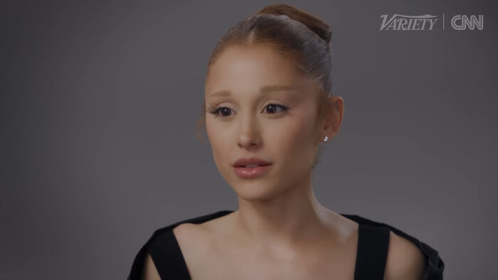 A female celebrity speaking in an interview, with a neutral gray background, related to celebrities people think suffer.