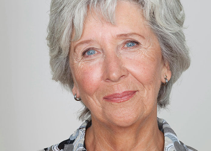 Close-up portrait of a mature woman with gray hair and blue eyes, representing shocked reactions to unhinged MIL comments.
