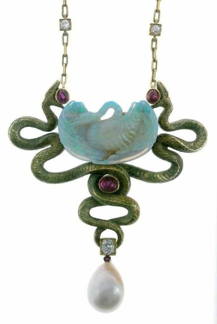 Antique necklace featuring serpents and a carved blue stone, reflecting emotion and culture in powerful old photos.