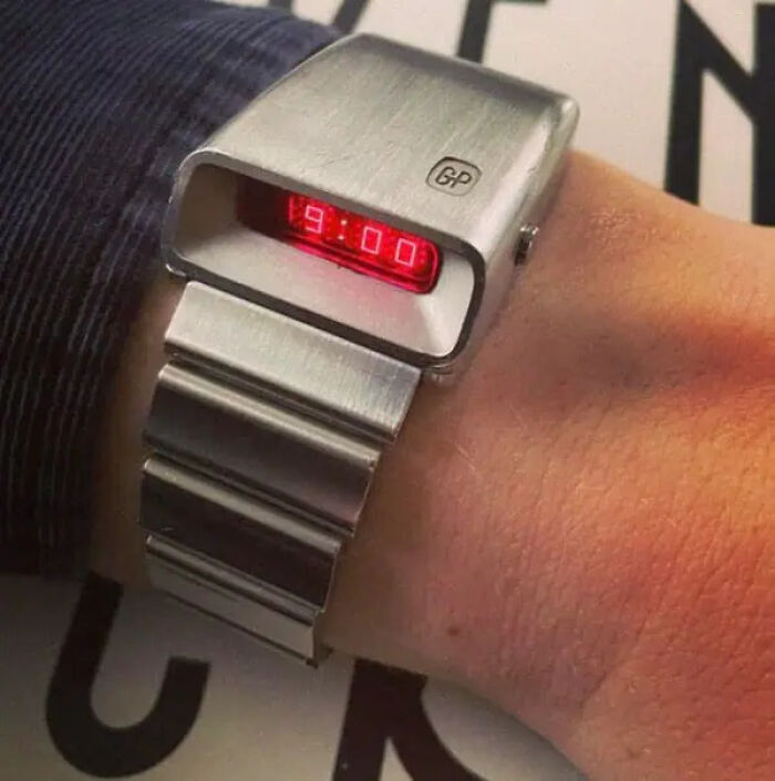 Close-up of a wrist wearing a trippy digital watch with a red LED display, showcasing unusual futuristic design elements.