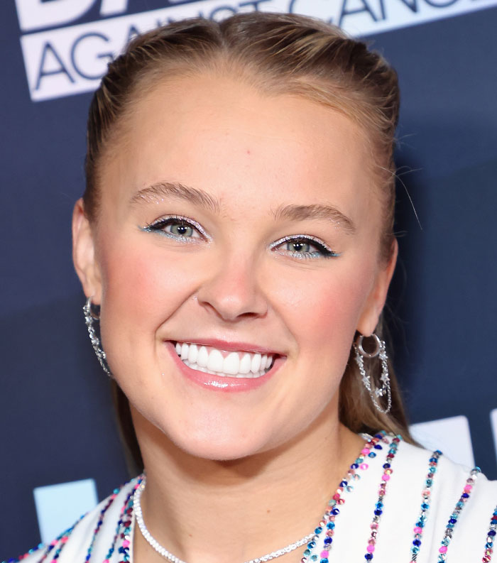 Young woman smiling at an event, representing one of the most disliked stars voted this year.