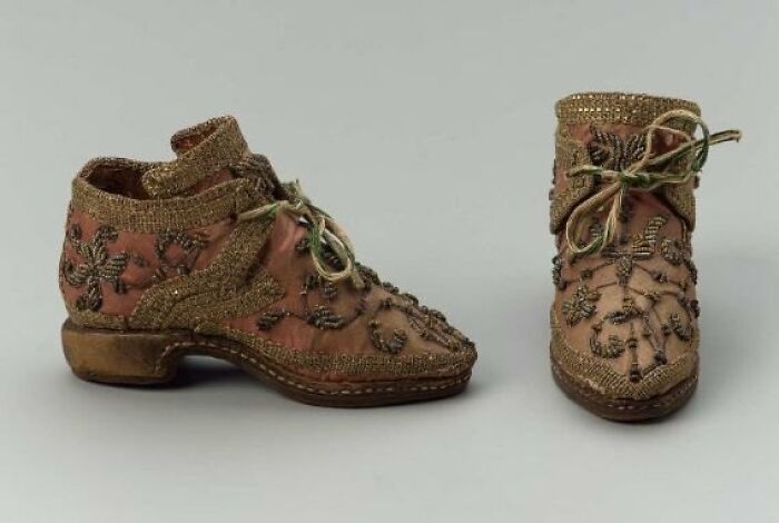 Pair of old embroidered shoes with laces, showcasing culture and everyday life through powerful vintage items.