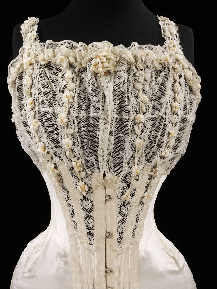 Vintage lace corset adorned with floral embroidery, representing culture and everyday life in the past through powerful old photos.