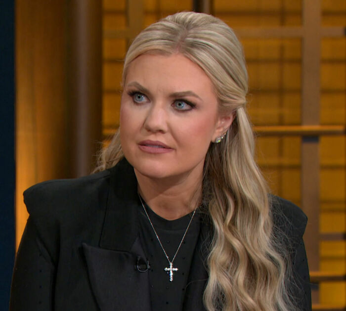 Erika Kirk speaking at an event, wearing a black jacket and cross necklace, highlighting a Freudian slip moment.