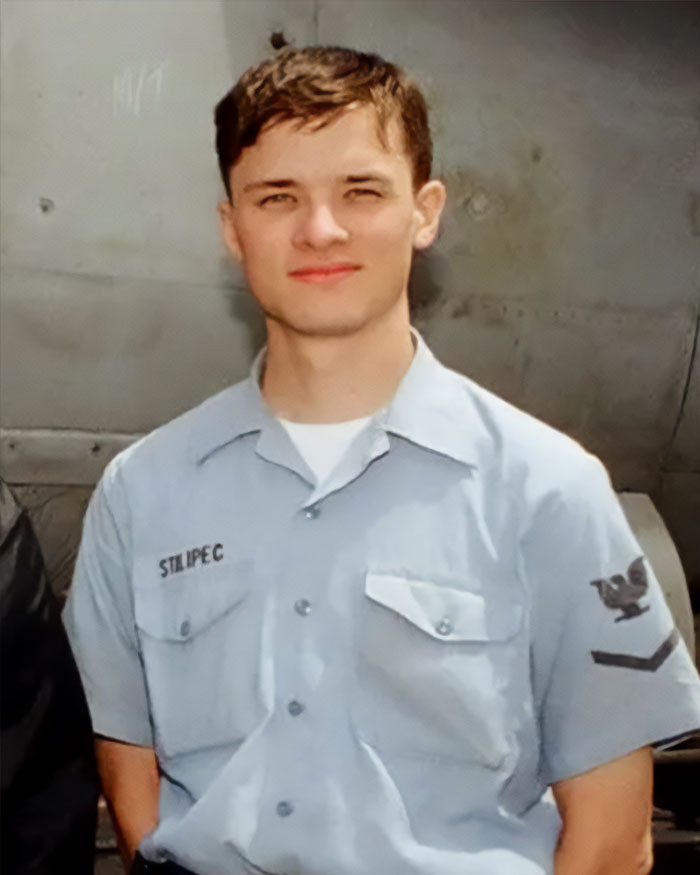 High school teacher in costume photos causing outrage among parents, wearing a blue uniform shirt standing indoors.
