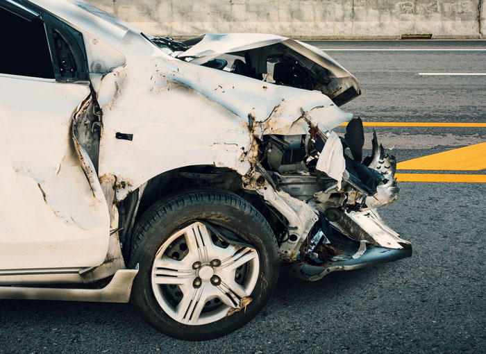 Damaged white car after a severe accident, illustrating one of the toughest things couples chose to forgive and what happened later.