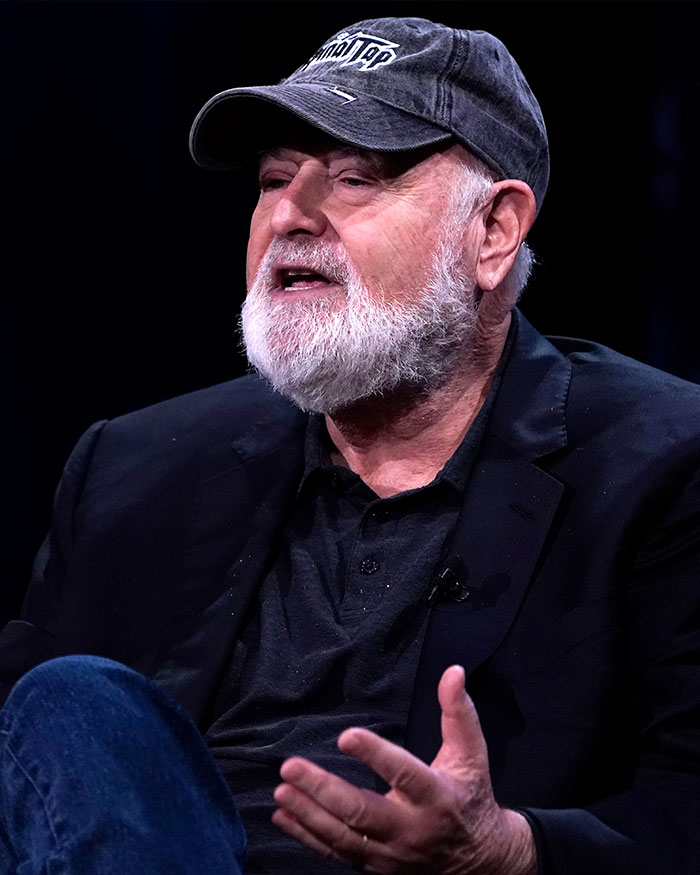 Rob Reiner speaking during an interview, wearing a black jacket, cap, and discussing the Christmas party incident. Rob Reiner speaking during an interview, wearing a black jacket, cap, and discussing the Christmas party incident.