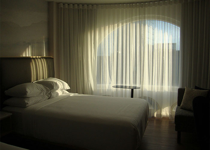 Minimalist hotel room with a neatly made bed and sheer curtains, evoking intimate encounters and K-drama-style dates. Minimalist hotel room with a neatly made bed and sheer curtains, evoking intimate encounters and K-drama-style dates.