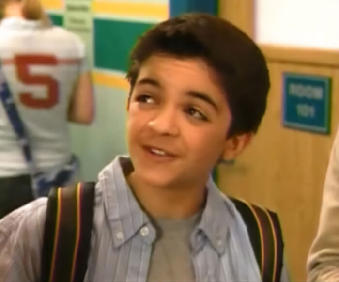 Young Nickelodeon star smiling in a school hallway, highlighting struggle with homelessness in a recent video.