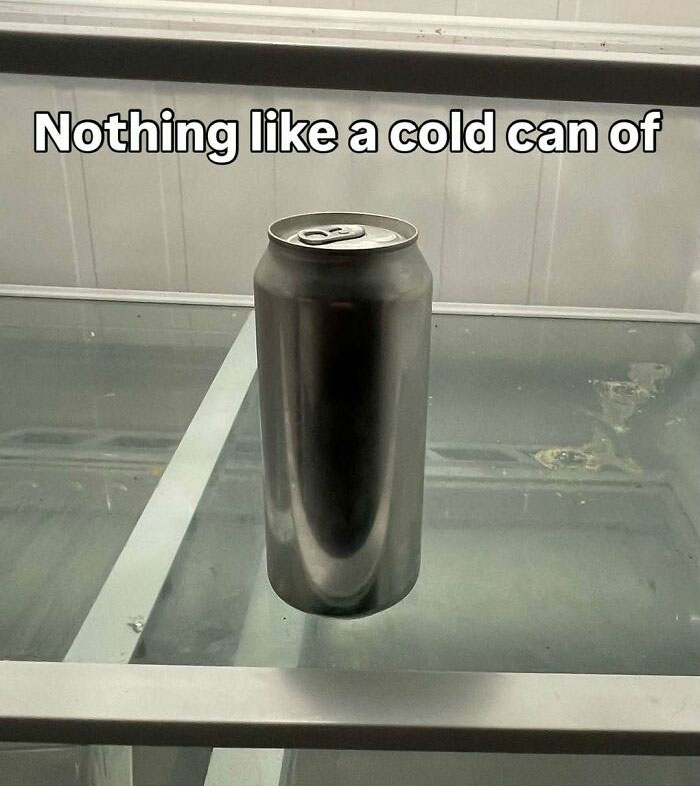 Empty silver can standing inside an empty fridge shelf, showcasing a minimal dude fridge scene with cold beverage.