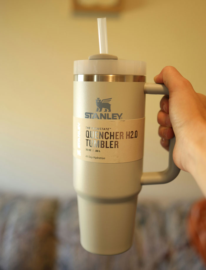Hand holding a Stanley Quencher H2.0 tumbler, a popular white elephant gift perfect for hydration and sharing.