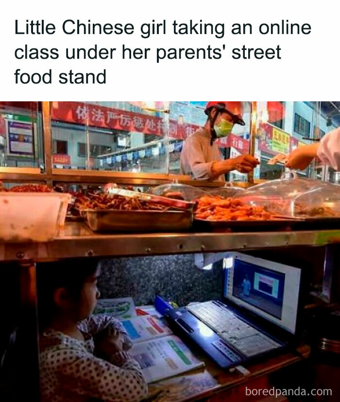 Little girl attending online class under street food stand, highlighting existence and reality in everyday life.